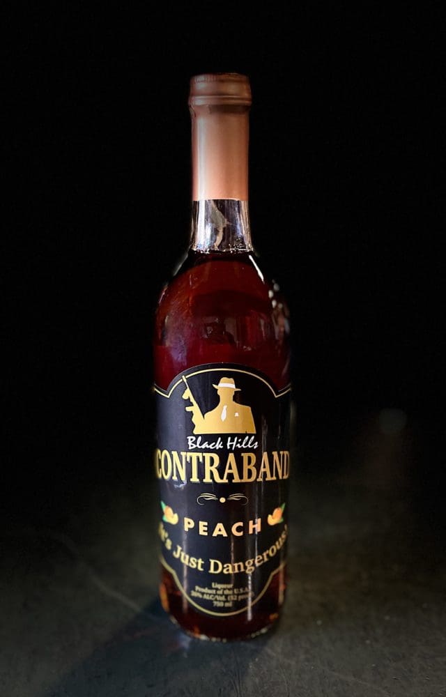 Bottle of peach liquor with a peach cap